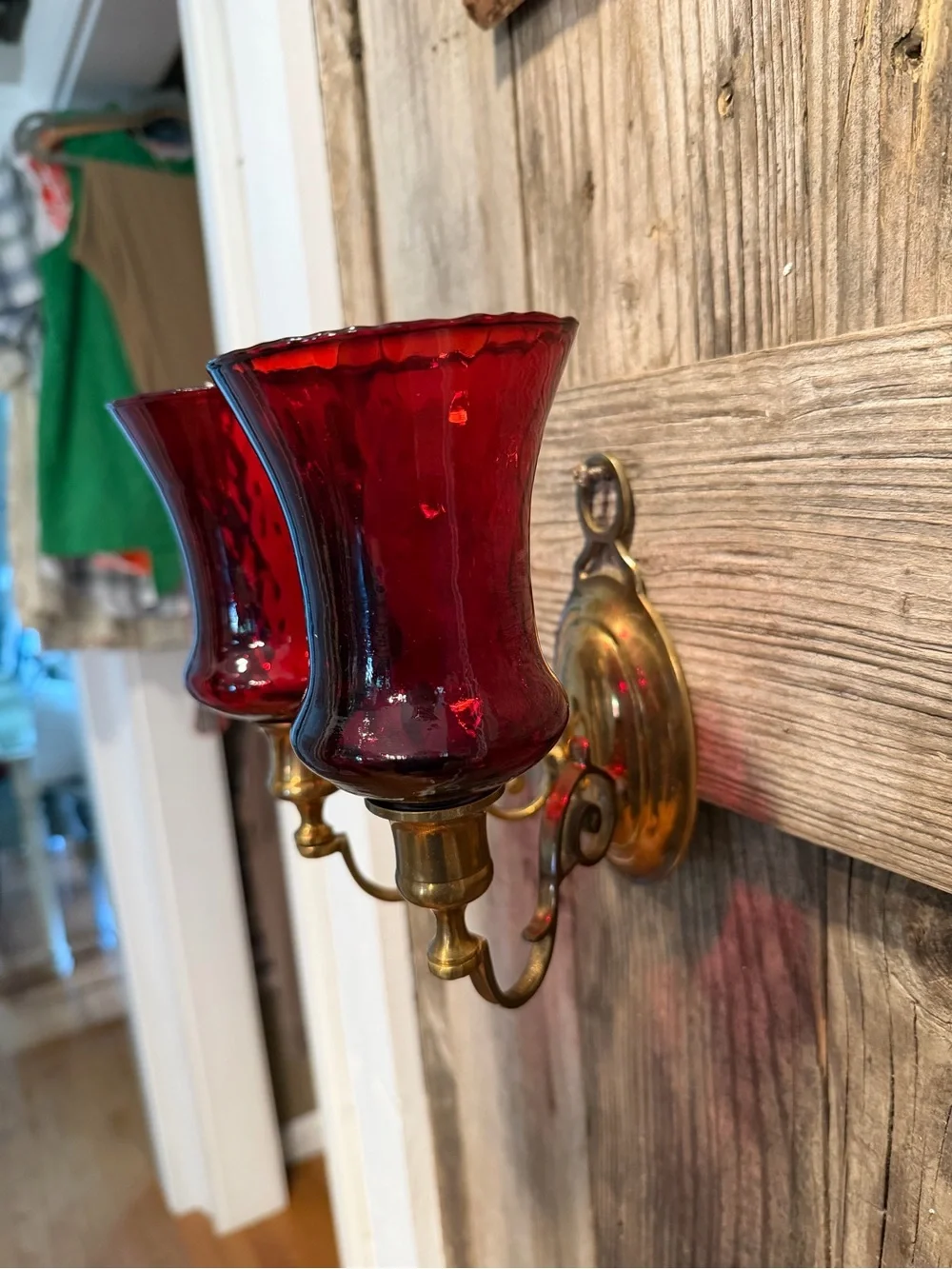 Vintage double-arm brass wall sconce fitted with ruby red votive cups